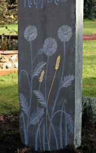 Relief carved flowers and gilded corn on Welsh slate standing stone